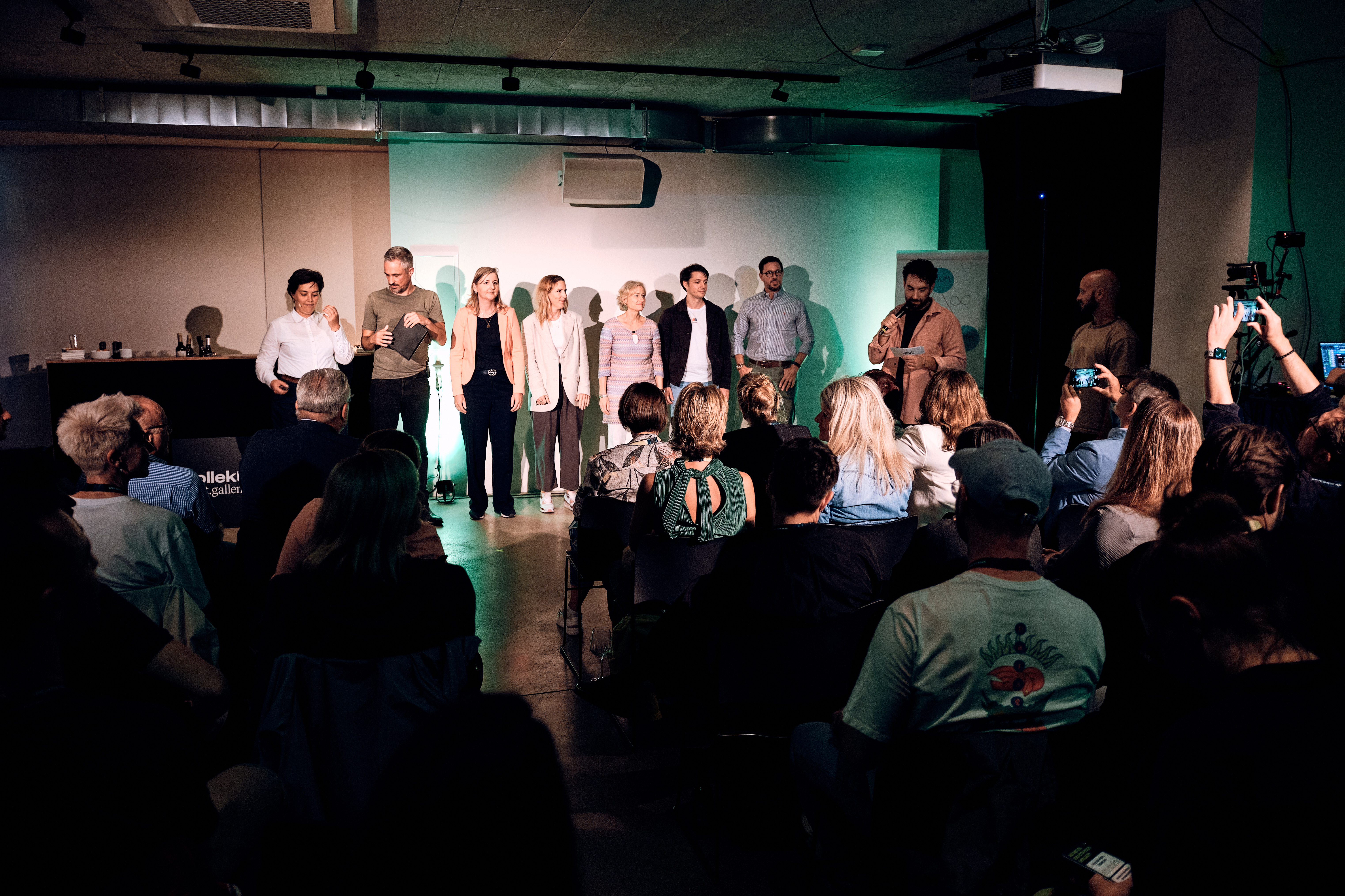 Die Speaker*innen stehen auf der Bühne und bekommen ihren Applaus.